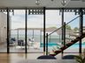 Glass wall opening onto a backyard pool