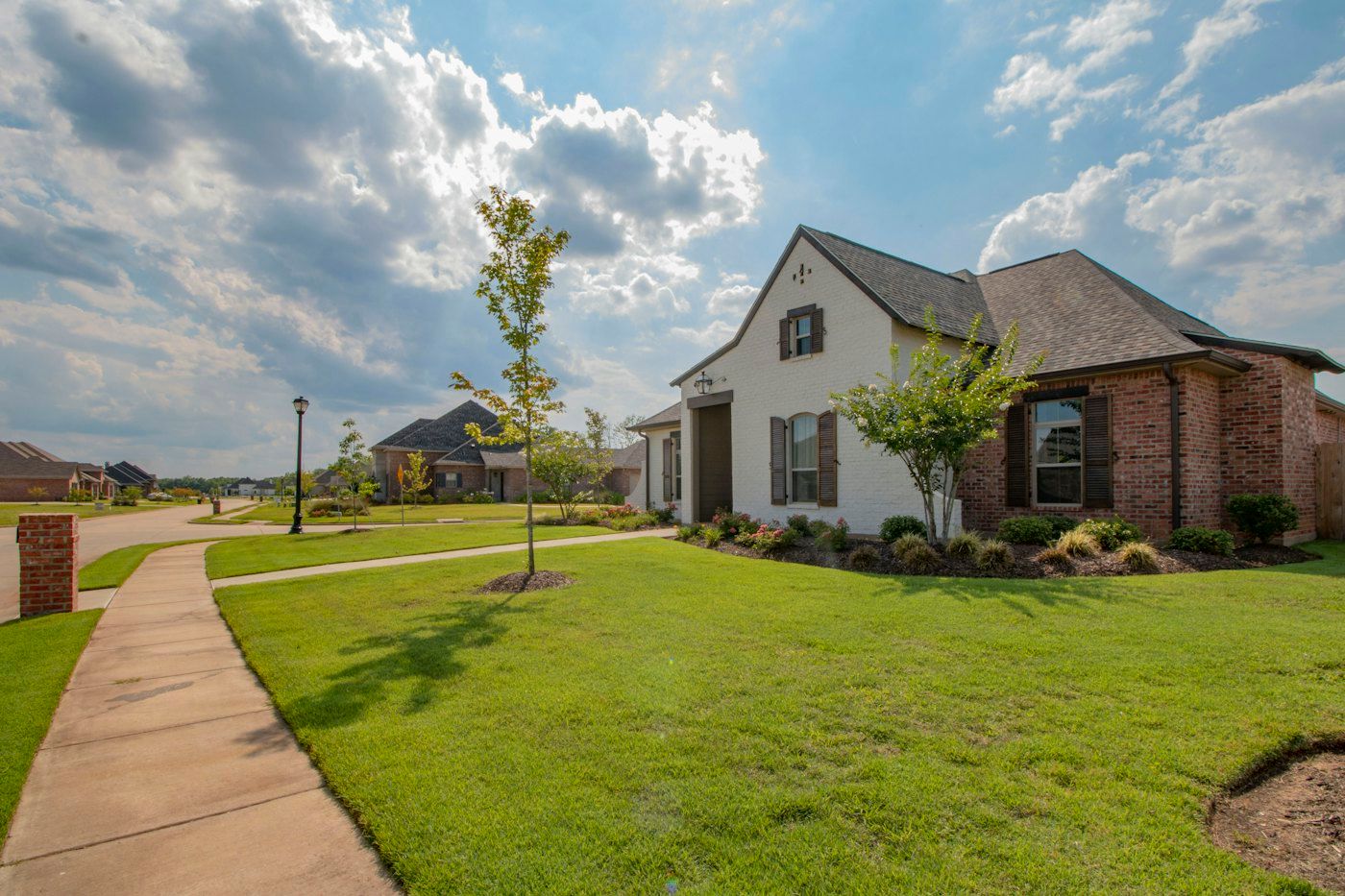 New-construction street with white brick homes and sidewalks