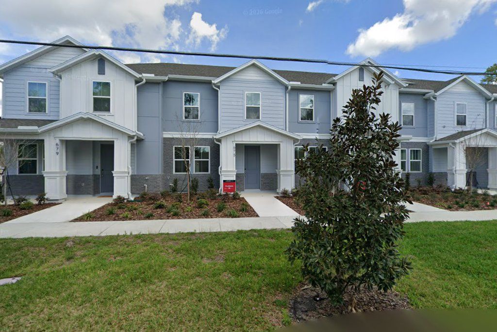 Row of new gray two-story townhomes with covered entries on Clark Street, Oviedo