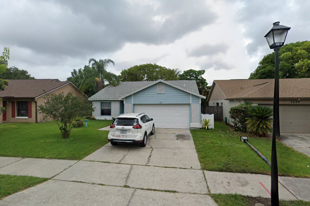 Light blue one-story home with a two-car garage on Covington Street, Oviedo
