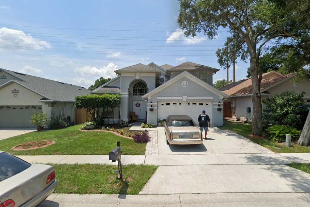 Two-story stucco home with an arched entry and a two-car garage on Easton Circle, Oviedo