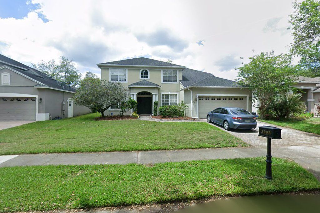 Two-story tan home with a two-car garage on Red Ash Circle, Oviedo